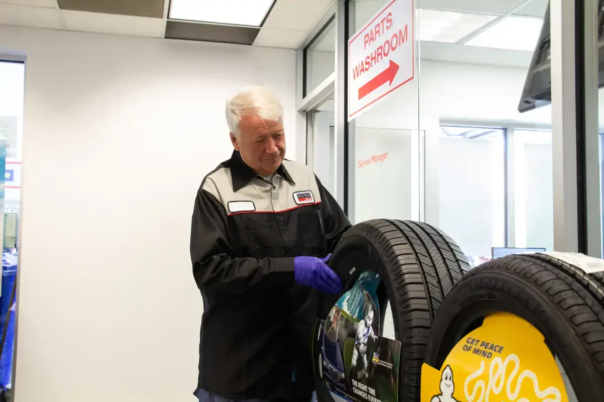 Tire technician inspecting car tires at WestWoodHonda Tire technician inspecting car tires at WestWoodHonda