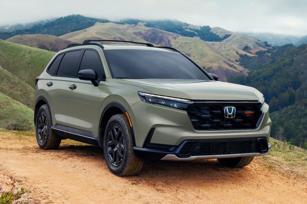 2026 Honda CR-V front three-quarter view parked on a dirt trail in green hills